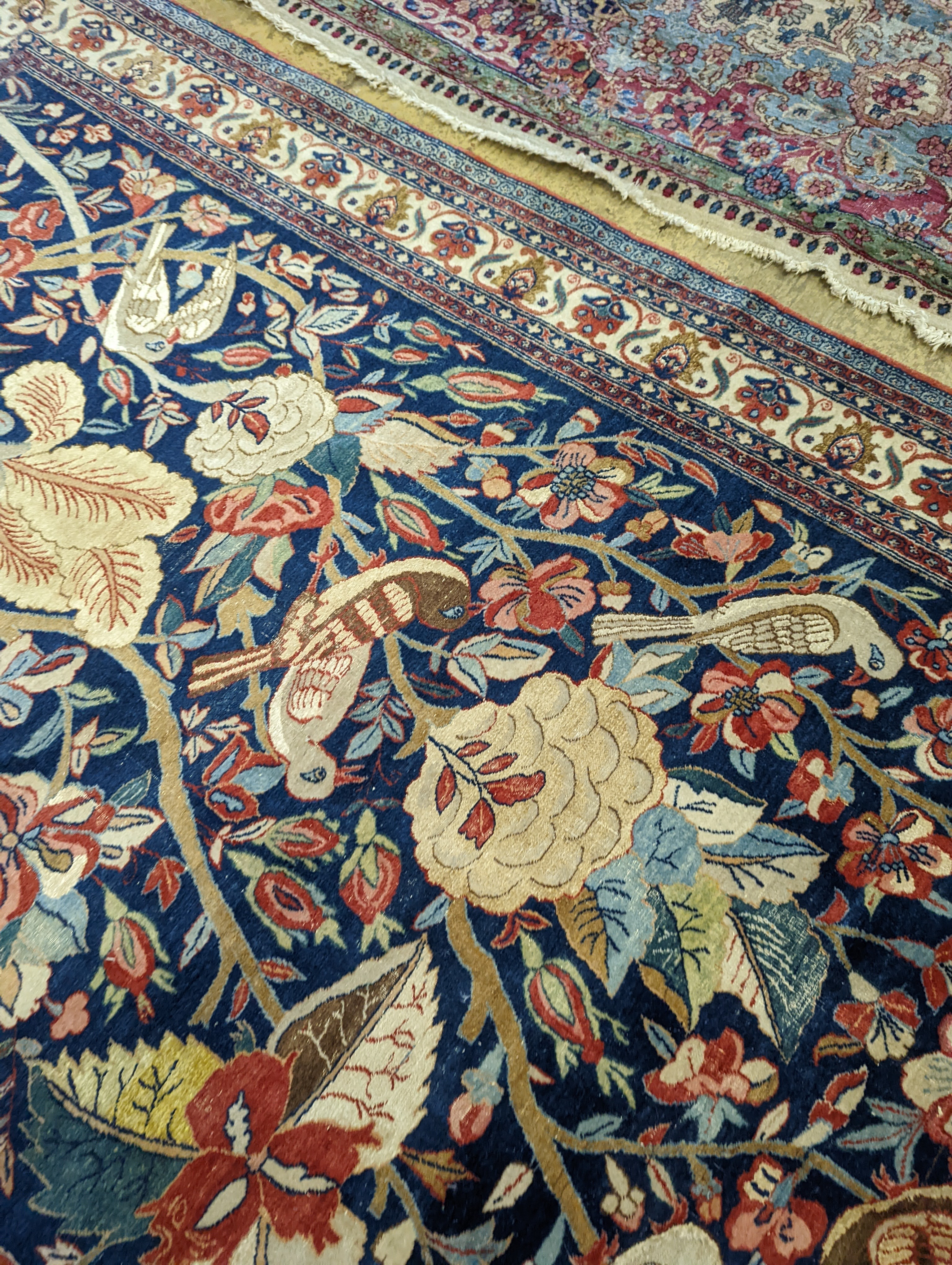 A Kirman blue ground rug woven with birds amongst flowering branches, 205 x 136cm